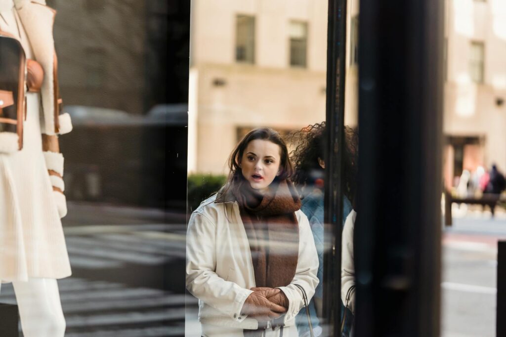 Amazed woman standing near glass showcase of store